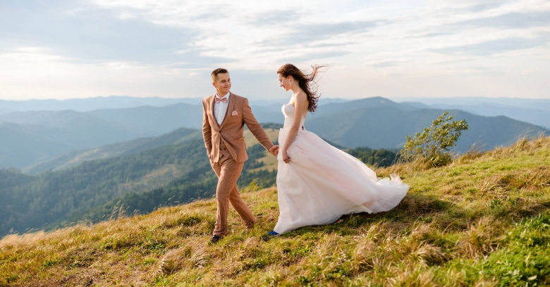 Bride and groom walking down mountain