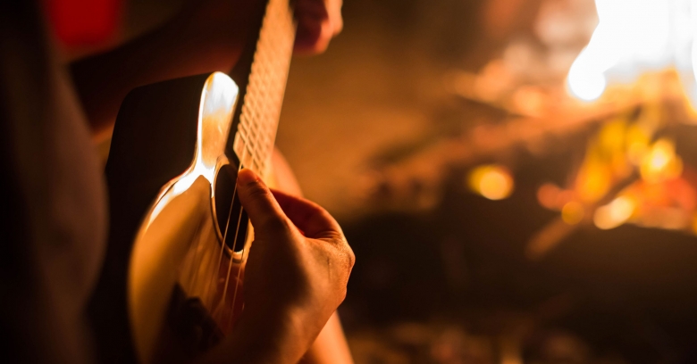 A hand strumming acoustic guitar