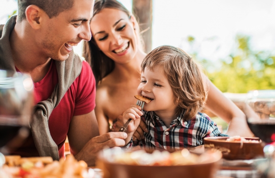 A mother, father, and child eating at a table