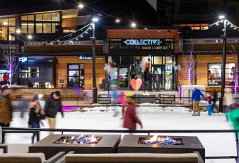People ice skating in an outdoor rink at night