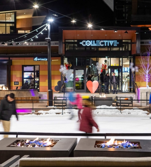 People ice skating in an outdoor rink at night