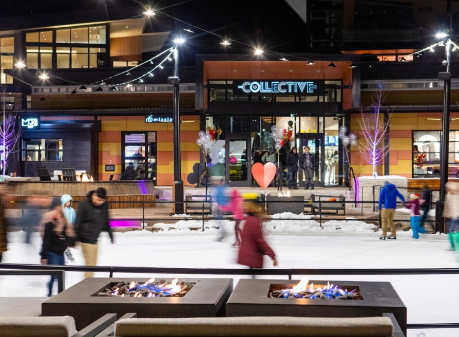 People ice skating in an outdoor rink at night