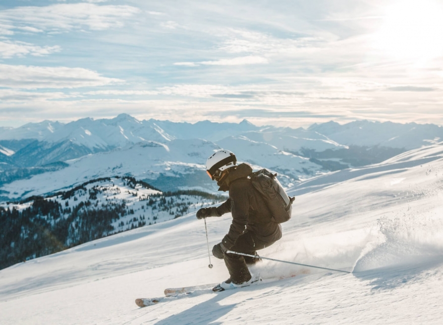 A skiier carving a turn down the mountain