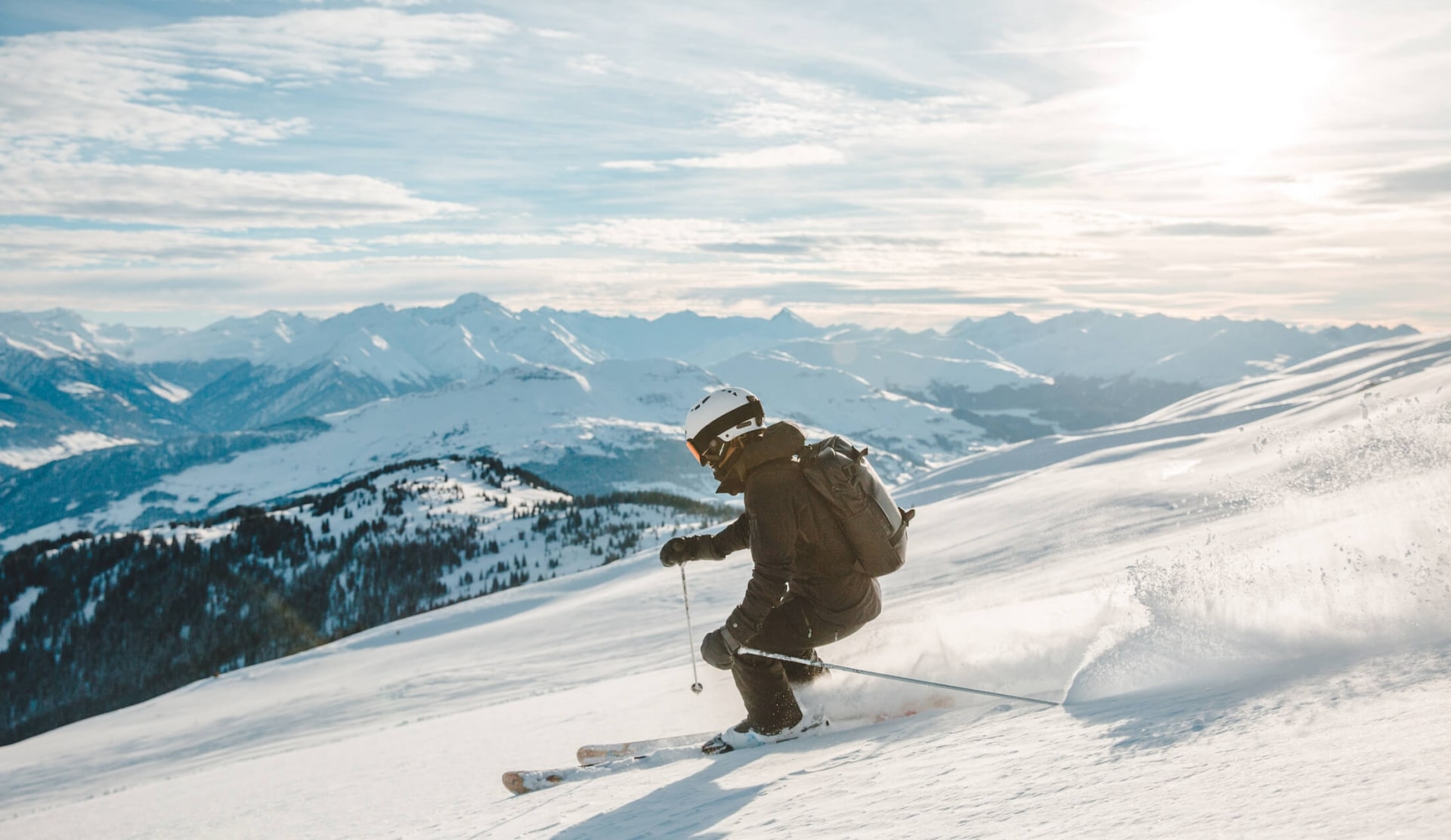 A skiier carving a turn down the mountain