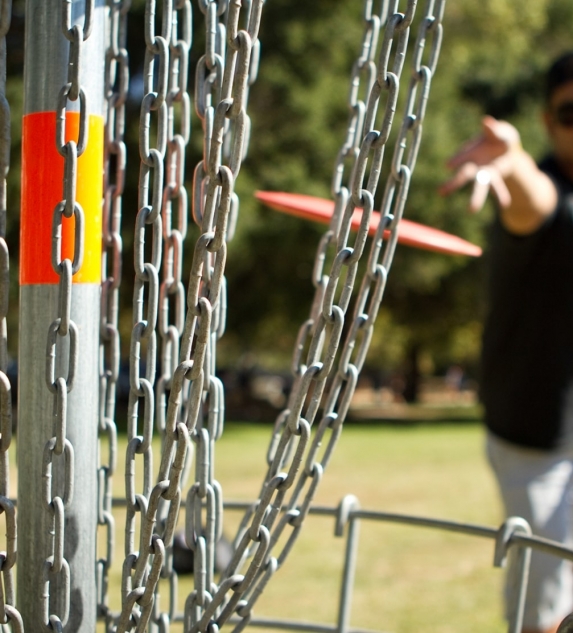 A man throwing a disk at a bunch of chains