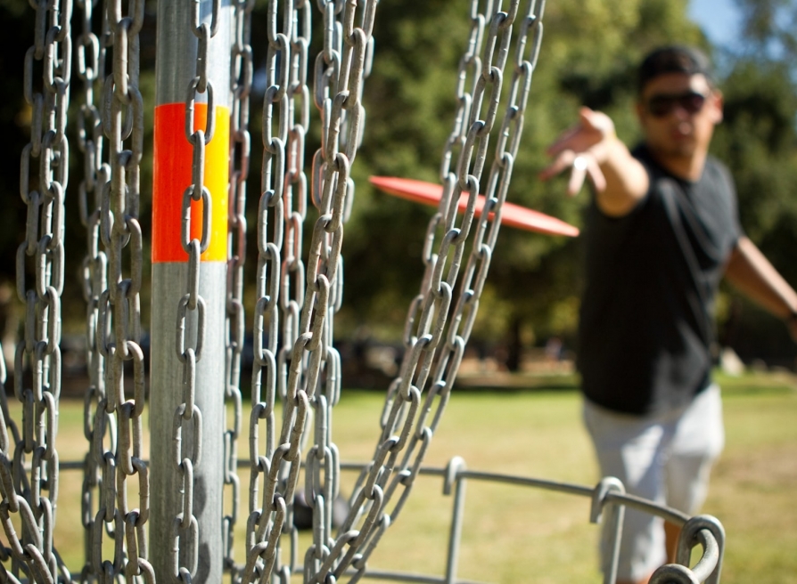 A man throwing a disk at a bunch of chains