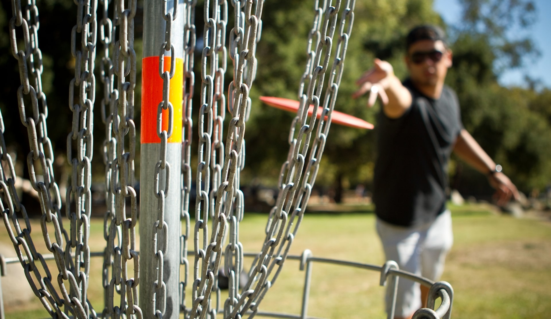 A man throwing a disk at a bunch of chains