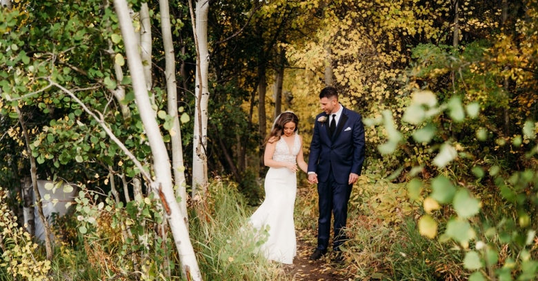 Bride and groom walking in the forest