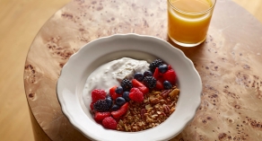 Bowl of Granola with fruits and yogurt and a cup of orange juice