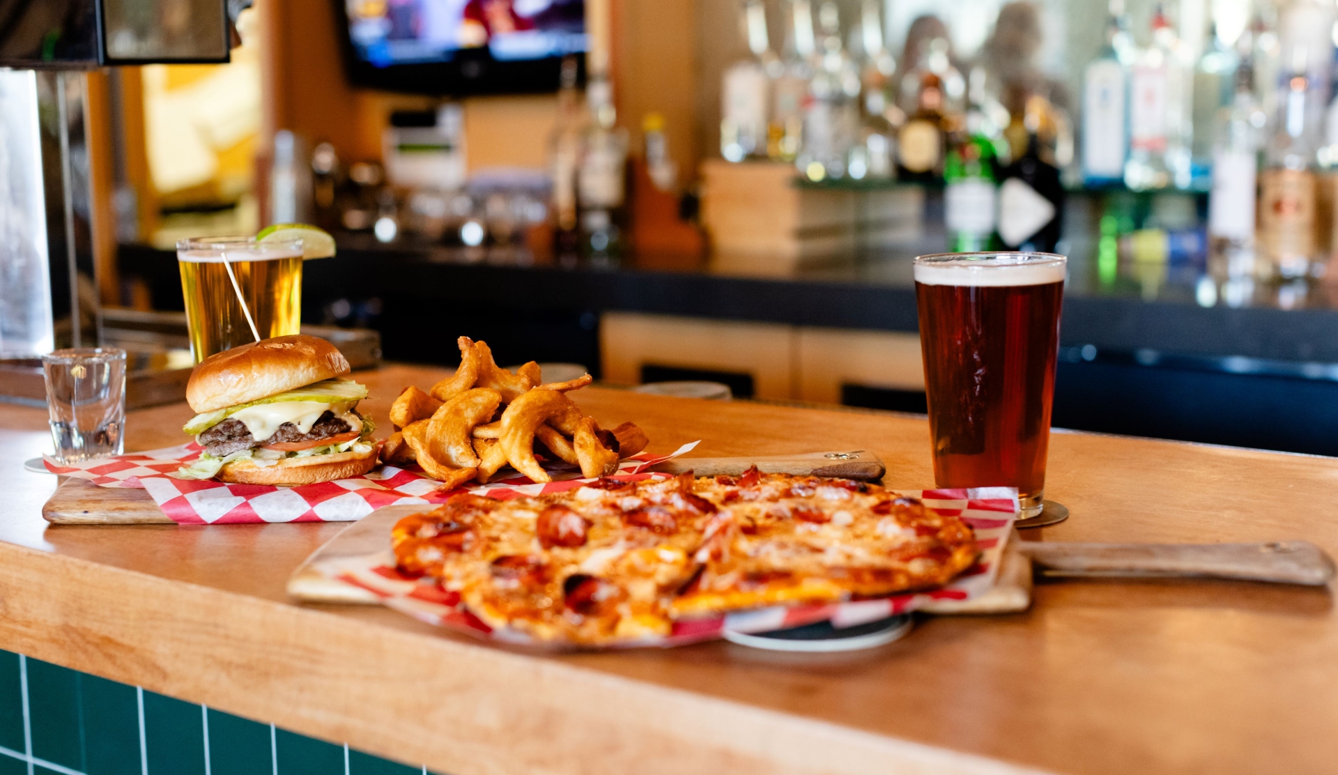 Pizza and beer sitting on a bar counter