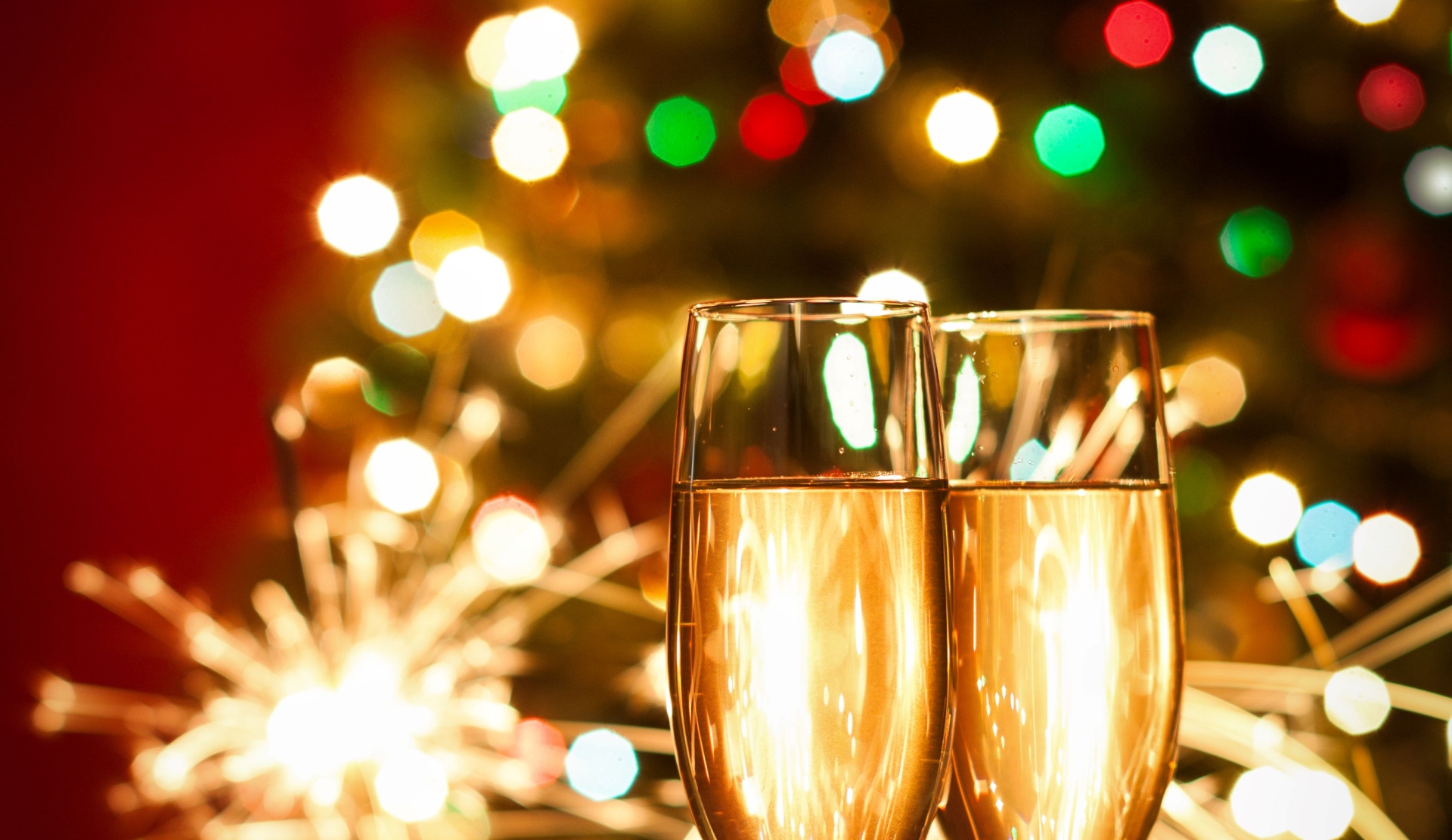 festive tree in background with sparkles and glasses of champagne in foreground